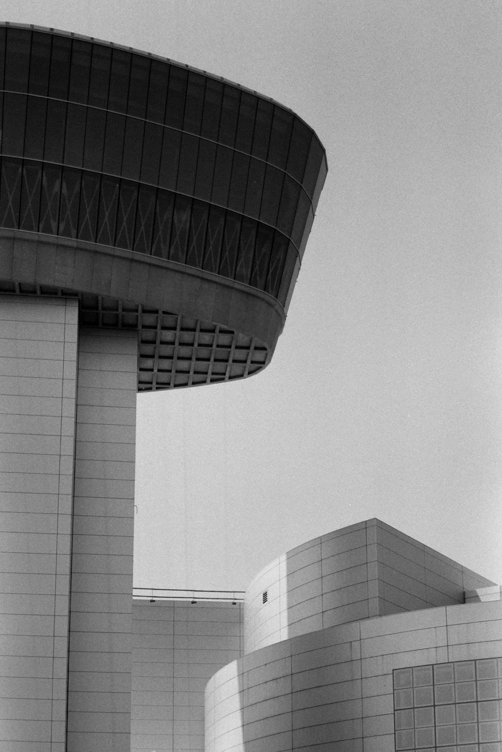 A curved white building facade against the sky